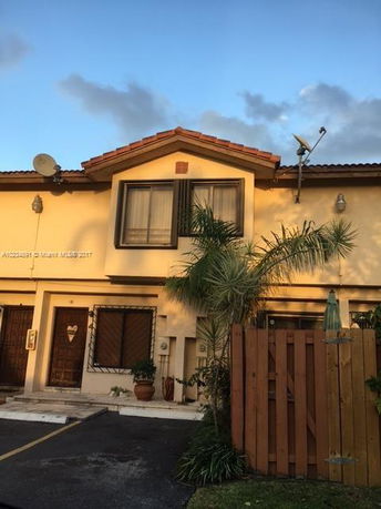 Front view of a two-story house with a balcony and satellite dishes.