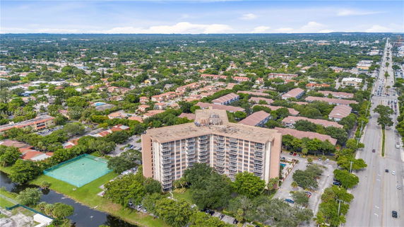 Aerial view of a multi-story apartment building surrounded by residential areas and greenery.