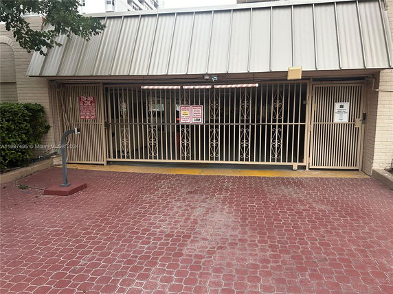Entrance to a covered parking area with metal gates.