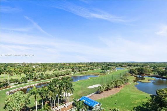 Scenic view of a golf course with water bodies and trees.