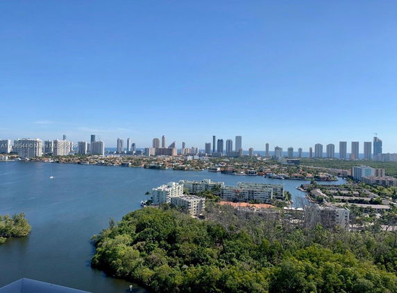 Panoramic view of a cityscape with high-rise buildings near a body of water.