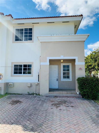 Front view of a two-story house with a small porch and a tiled roof.