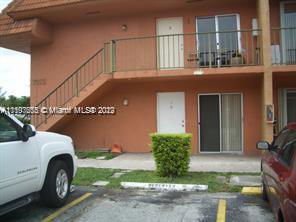 Outdoor parking area in front of a two-story building.