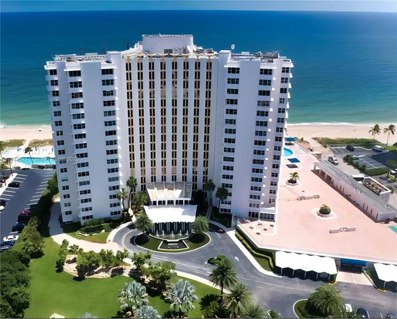 Front view of a high-rise beachfront building with a rounded entrance driveway.