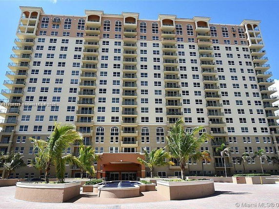 Front view of a multi-story residential building with multiple balconies.