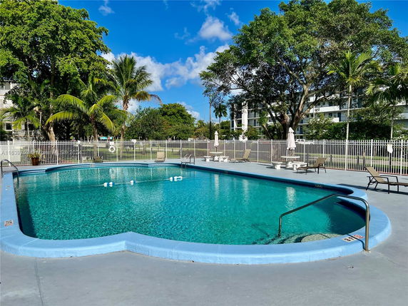 Outdoor swimming pool with surrounding deck and trees.