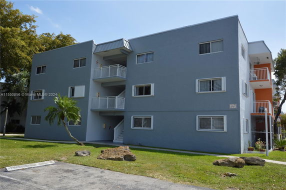 Front view of a three-story apartment building with balconies.
