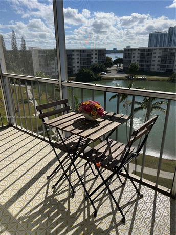 View from a balcony showing nearby buildings and a body of water in the distance.