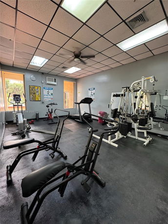 Interior view of a gym room with exercise equipment and workout machines.