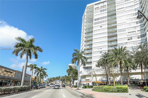 Front view of a high-rise residential building with multiple balconies.