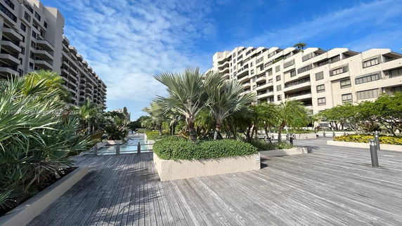 View of multi-story building from an exterior area with a deck and plants.