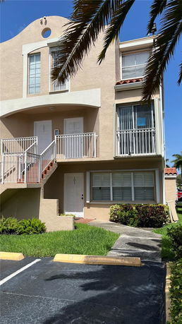 Front view of a two-story residential building with balconies and multiple entrances.