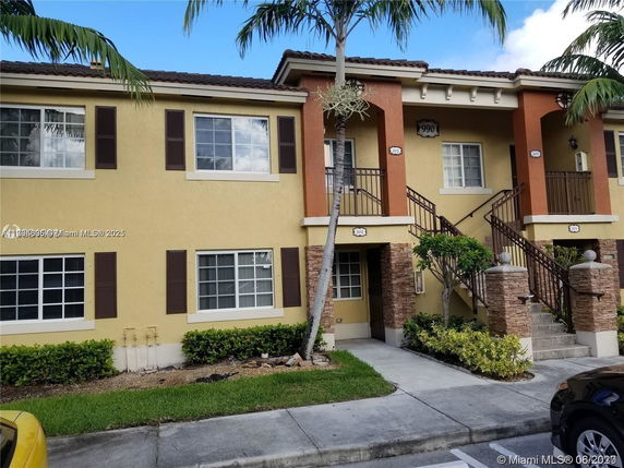 Front view of a two-story apartment building with stairs leading to upper-level entrances.