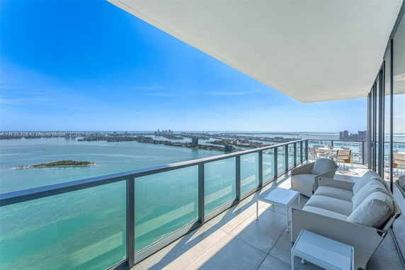 Wide-angle view from a balcony overlooking a large body of water and cityscape.