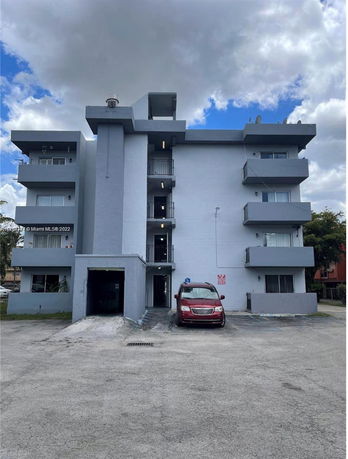 Front view of a multi-story residential building with balconies.