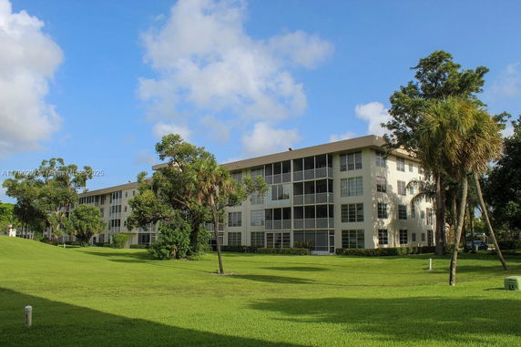 Front view of a multi-story apartment building with large windows and balconies.