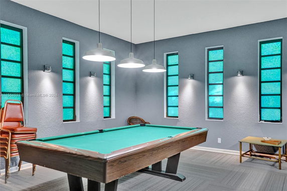 Room with pool table and modern lighting in a recreational space.
