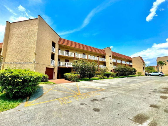 Front view of a three-story apartment building with balconies.
