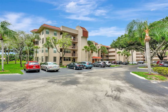 Outdoor parking area in front of a multi-story residential building.
