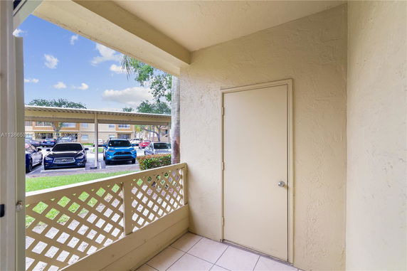 Outdoor view with covered parking and multiple cars.
