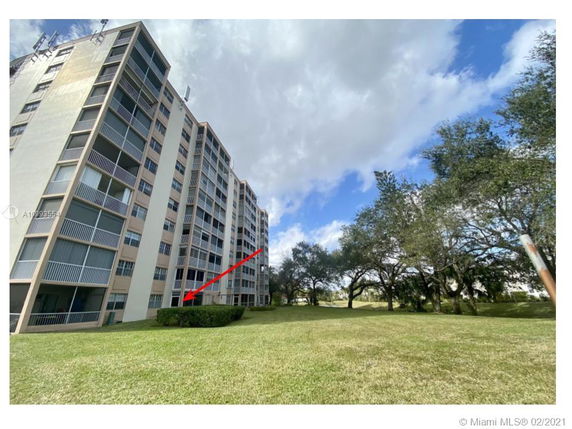 Front view of a multi-story apartment building with several balconies.