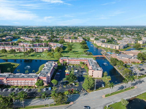 Wide-angle aerial view of apartment complexes with ponds and green spaces.