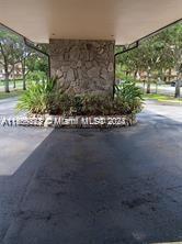 Outdoor parking area with a stone wall feature and surrounding greenery.