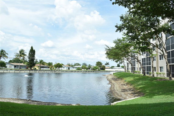 View of a lakeside residential area with multiple houses and a building visible near the shoreline.