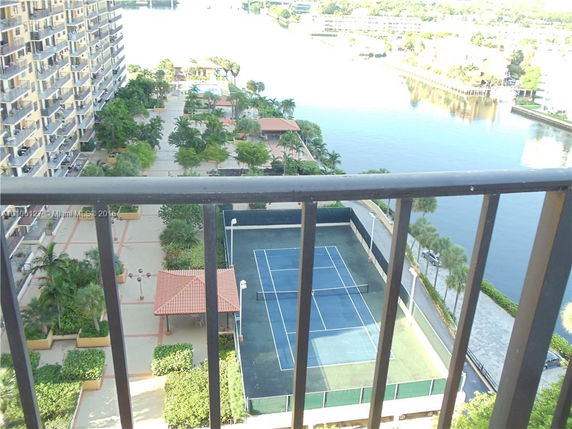 View of surrounding areas with a tennis court and waterway from an elevated position.