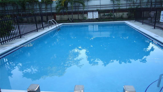 Outdoor swimming pool with surrounding fence.
