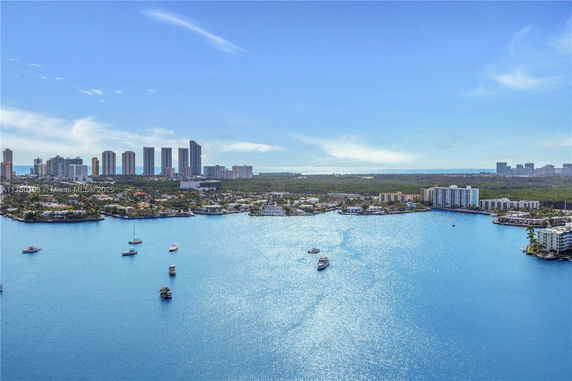 Panoramic view of a cityscape with water, tall buildings, and boats.