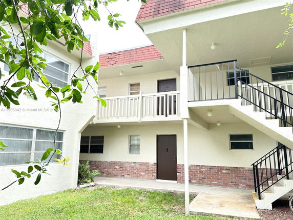 Front view of a multi-story building with exterior stairs and balconies.
