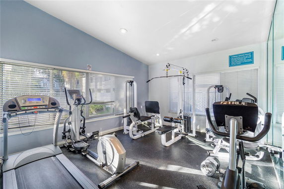 Indoor fitness area with gym equipment including a treadmill, elliptical, and weight machine.