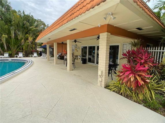 Outdoor area with a swimming pool and covered patio.