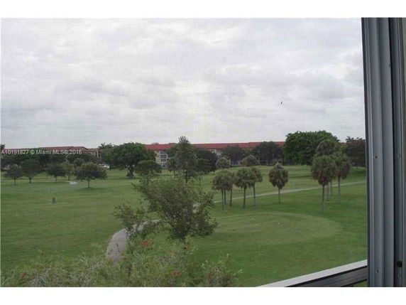 Scenic view of a green area with trees, seen from a building.