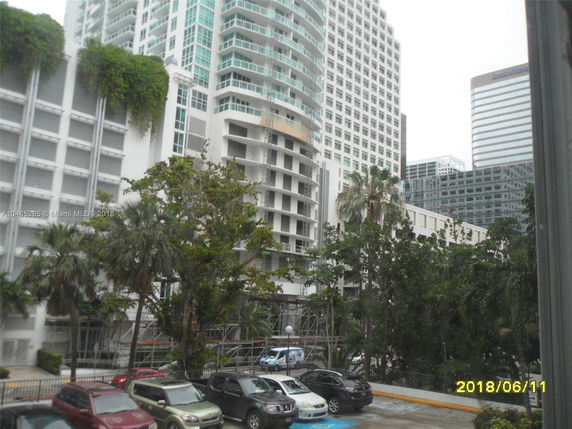 View of tall buildings and surrounding foliage in an urban setting.