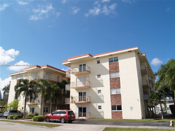 Front view of a multi-story residential building with balconies.