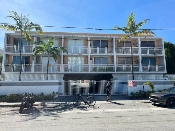 Front view of a three-story apartment building with balconies.