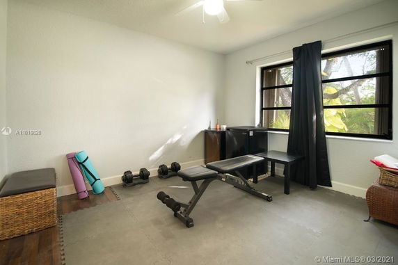 Interior of a home gym with exercise equipment and mats.