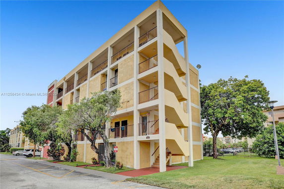 Front view of a multi-story apartment building with external staircases.