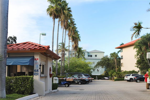 Outdoor parking area with parked cars and a small guardhouse.