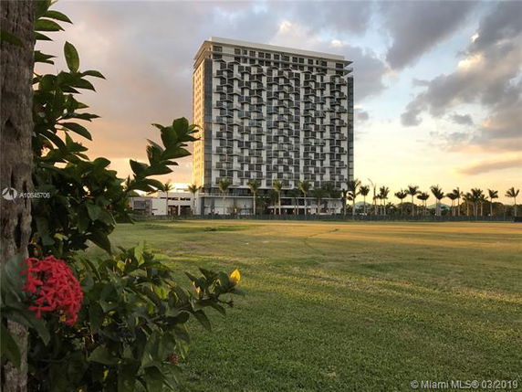 Front view of a multi-story modern building with a grid-like balcony pattern.