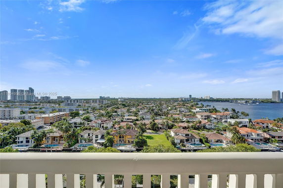 Panoramic view of a cityscape with buildings and water in the distance.