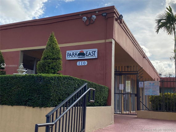 Front view of a building with signage 'Park East 110' and a gated entrance.