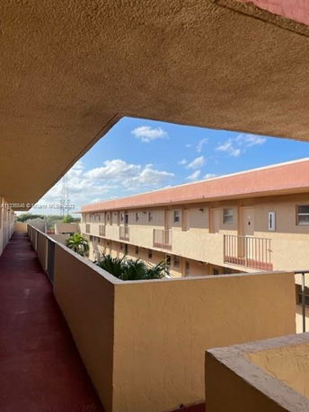 View of a multi-story residential building with balconies and a clear blue sky.