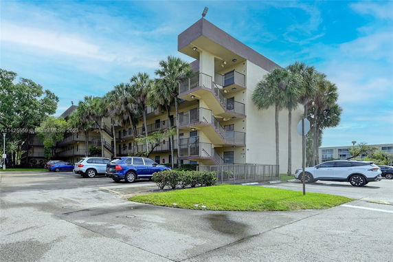 Front view of a multi-story apartment building with external staircases.