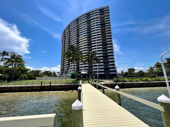 Front view of a tall, curved residential building near the waterfront.