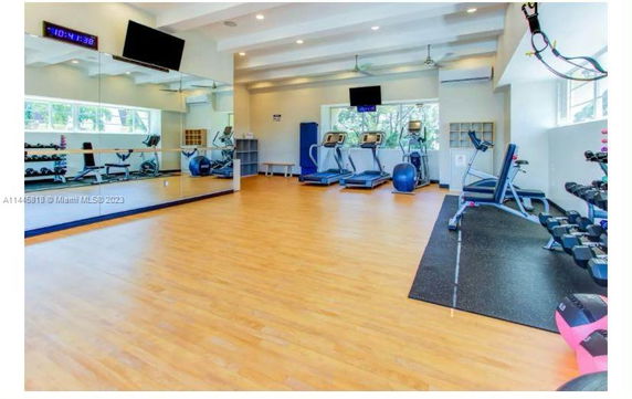 Indoor gym area equipped with exercise machines and weights.