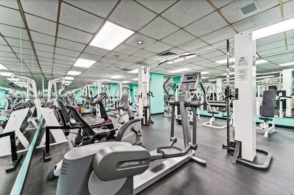Indoor gym with various exercise machines and equipment.