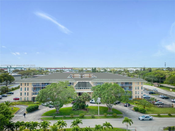 Front view of a multi-story building with a parking area in front.